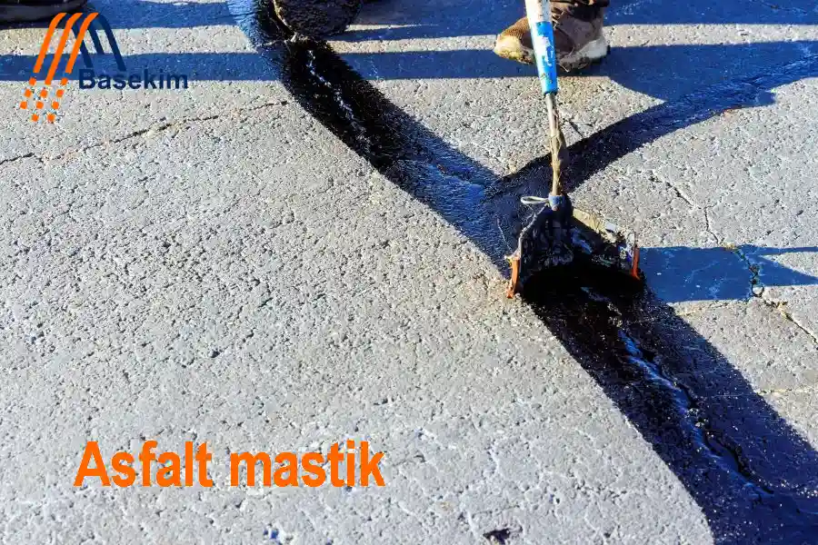 Bir işçinin asfalt mastik uygulaması sırasında çatlak doldurma işlemi yaptığı an – Basekim